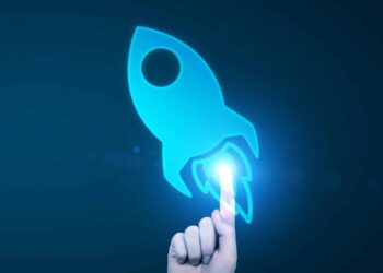 A hand pointing at a blue rocket icon on a dark background, symbolizing innovation or technology.