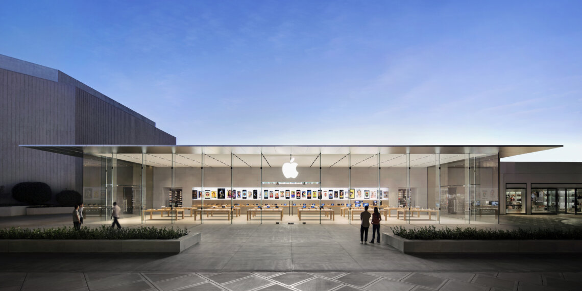 Exterior view of an Apple Store featuring a glass facade and the Apple logo.