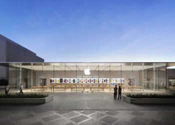 Exterior view of an Apple Store featuring a glass facade and the Apple logo.