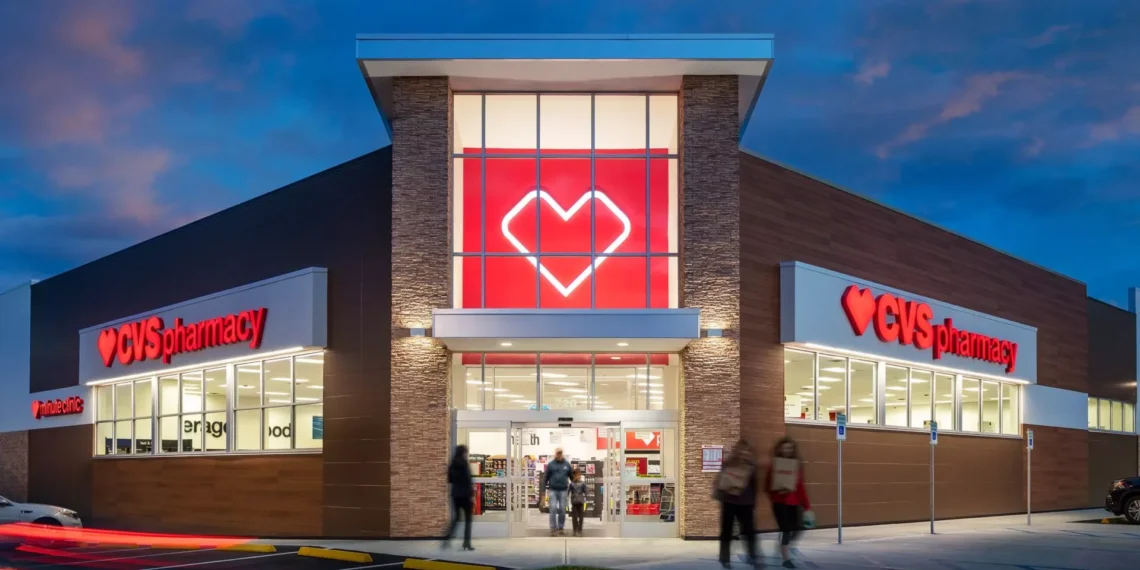 Exterior view of a CVS Pharmacy store with a prominent heart logo and illuminated signage at dusk.