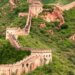 The Great Wall of China winding through a mountainous area covered in greenery.