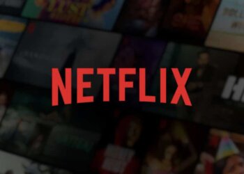 Netflix logo displayed prominently against a blurred background of various streaming content thumbnails.