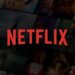 Netflix logo displayed prominently against a blurred background of various streaming content thumbnails.