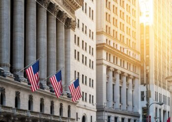 Exterior view of the New York Stock Exchange building featuring American flags.
