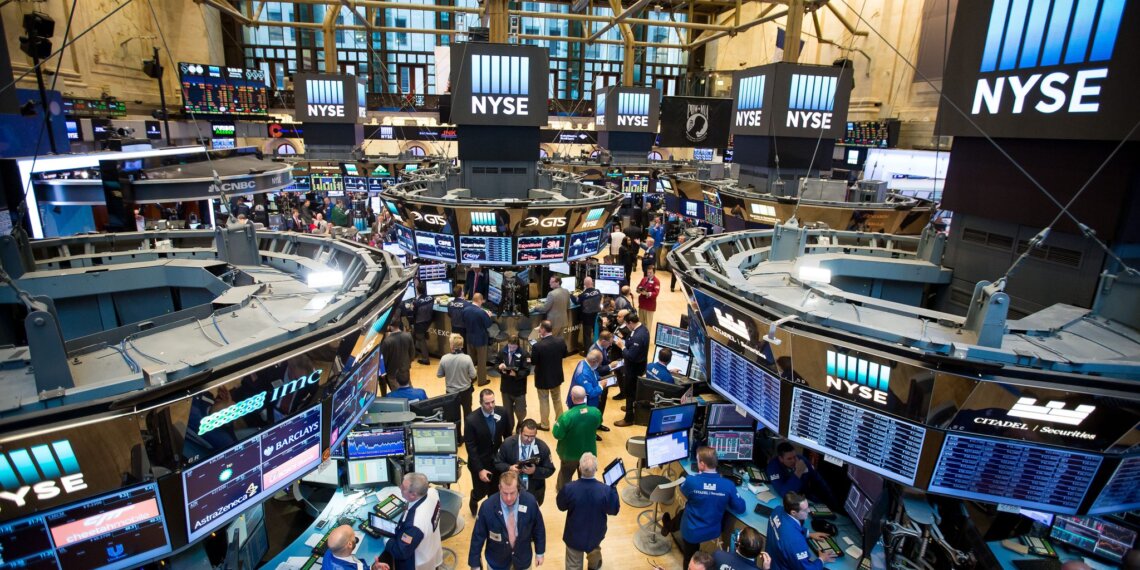 View of the trading floor at the New York Stock Exchange with multiple screens and traders.