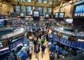 View of the trading floor at the New York Stock Exchange with multiple screens and traders.