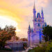 Cinderella Castle illuminated at sunset with a colorful sky in the background.