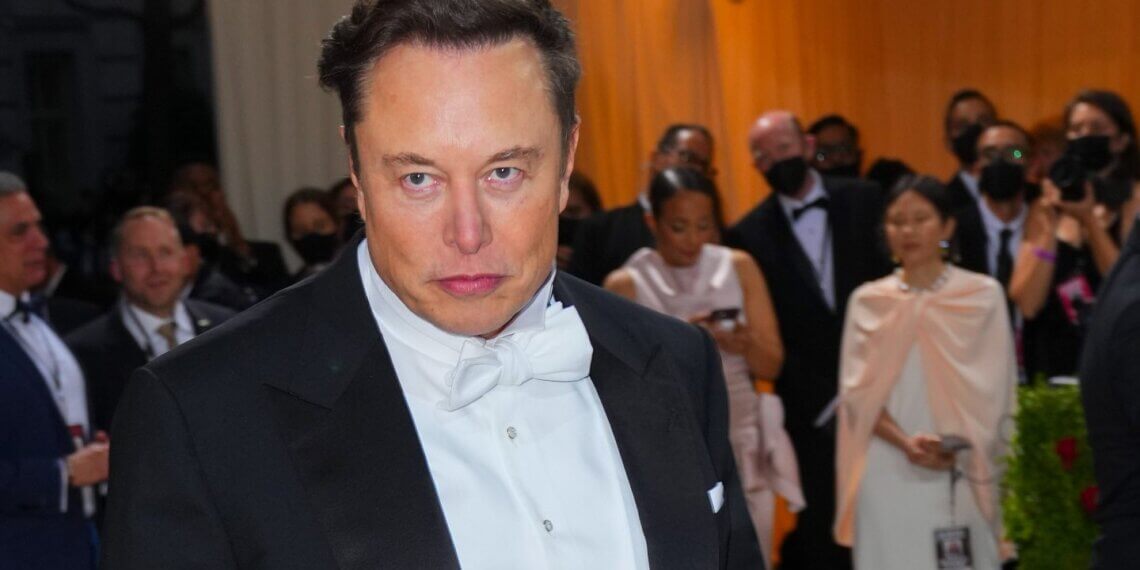 Elon Musk wearing a tuxedo with a bow tie at a formal event, looking directly at the camera.