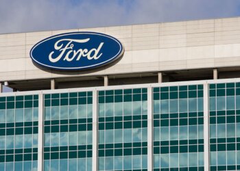 Exterior view of the Ford Motor Company headquarters building with the Ford logo on display.