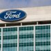 Exterior view of the Ford Motor Company headquarters building with the Ford logo on display.