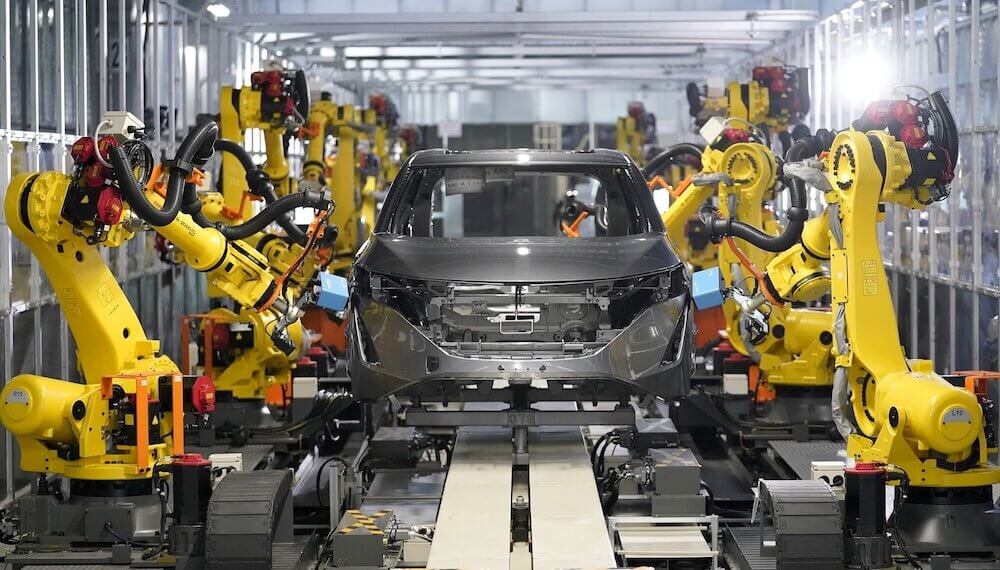 Robots assembling a car in Nissan's intelligent factory environment with a focus on automation.