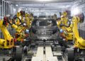 Robots assembling a car in Nissan's intelligent factory environment with a focus on automation.