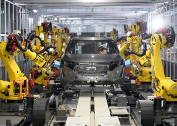 Robots assembling a car in Nissan's intelligent factory environment with a focus on automation.