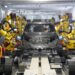 Robots assembling a car in Nissan's intelligent factory environment with a focus on automation.