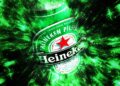 Heineken beer bottle with a green and black abstract background effect.