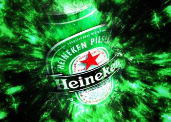 Heineken beer bottle with a green and black abstract background effect.