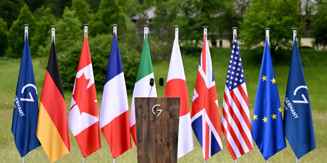 Wooden podium in front of various international flags including Germany, USA, and Japan.