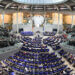 Interior view of the German Bundestag Plenary Hall with seating and a central stage.