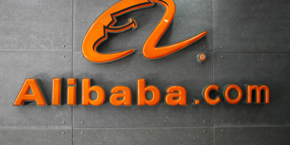 Orange Alibaba.com logo displayed on a gray wall with a modern design.
