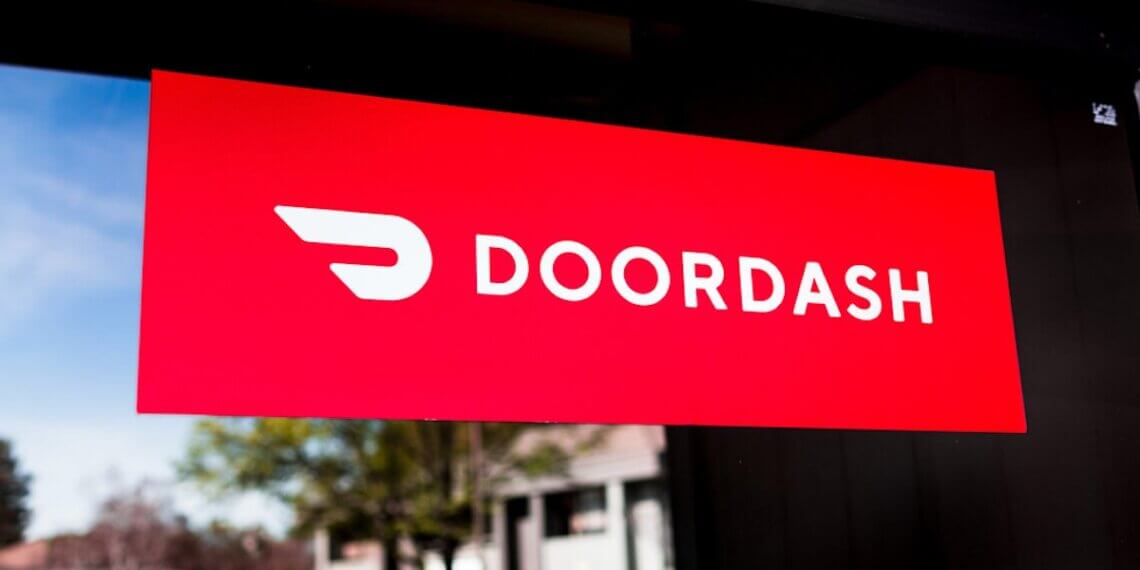 Red sign displaying the DoorDash logo with a stylized delivery icon.