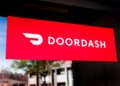 Red sign displaying the DoorDash logo with a stylized delivery icon.