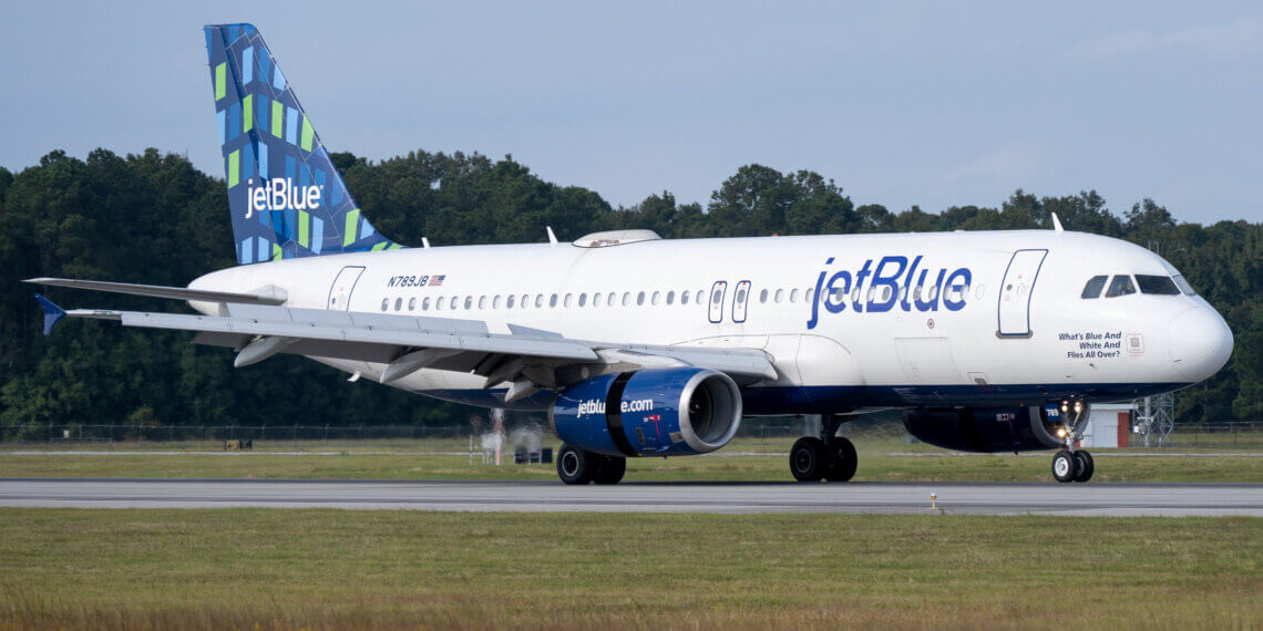 JetBlue Airways Airbus A320-232 airplane on the runway with a blue and green tail design.