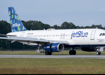 JetBlue Airways Airbus A320-232 airplane on the runway with a blue and green tail design.