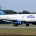 JetBlue Airways Airbus A320-232 airplane on the runway with a blue and green tail design.