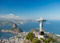 Christ the Redeemer statue with arms outstretched, overlooking Rio de Janeiro and the ocean.