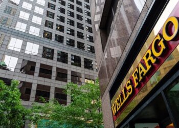 Wells Fargo bank signage displayed on a building with reflective glass windows.