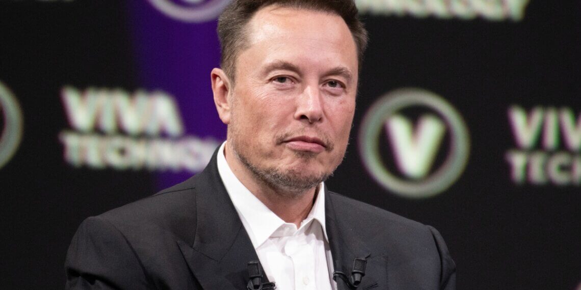 Elon Musk seated on stage during the Viva Technology conference with a serious expression.