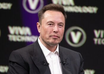 Elon Musk seated on stage during the Viva Technology conference with a serious expression.