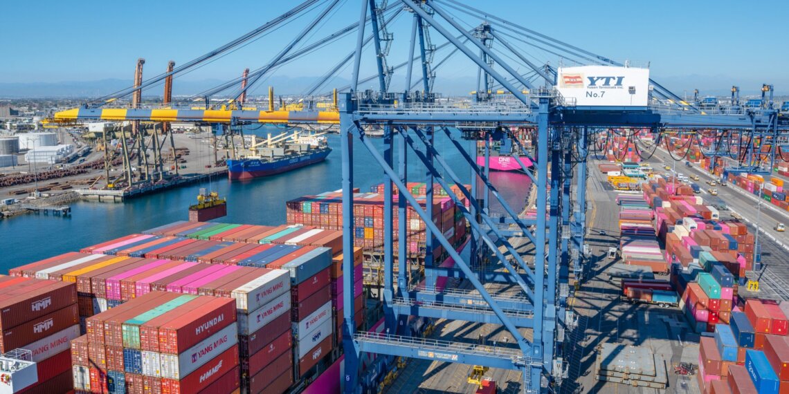Container terminal at the Port of Los Angeles with cranes and stacked shipping containers.