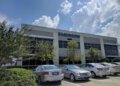 Exterior view of the Emerson corporate office building with a clear sky and parked cars.