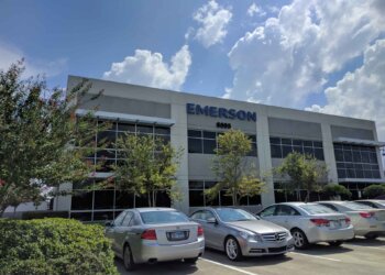 Exterior view of the Emerson corporate office building with a clear sky and parked cars.