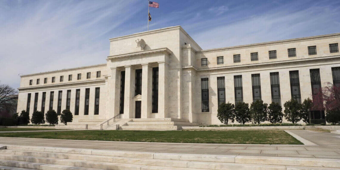 The Federal Reserve building in Washington, D.C. with a flag on top and steps leading to the entrance.