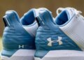 Close-up view of the back of Under Armour HOVR Drive spikeless golf shoes in blue and white.