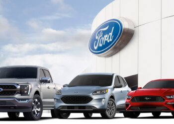 Three Ford vehicles displayed in front of a Ford logo on a building.