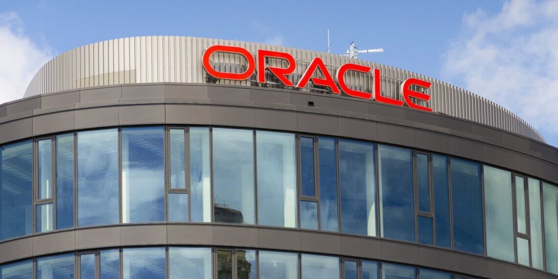 Exterior view of the Oracle building featuring large glass windows and the Oracle logo on the roof.