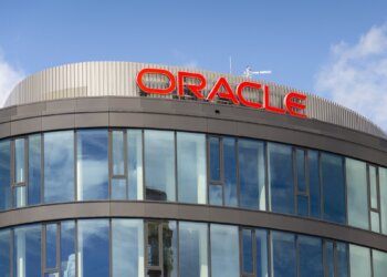 Exterior view of the Oracle building featuring large glass windows and the Oracle logo on the roof.