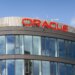 Exterior view of the Oracle building featuring large glass windows and the Oracle logo on the roof.