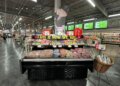 Meat display case featuring various cuts of meat and a promotional sign in a grocery store.